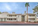 Multi-level building exterior with tan stucco, balconies, and mature landscaping at 3790 Shirebrook Dr # 167, Las Vegas, NV 89115
