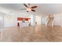 Open concept living room with tile flooring, ceiling fan, and kitchen view at 4740 Killington St, Las Vegas, NV 89129