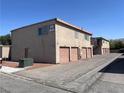 Apartment building featuring individual garages, exterior stairs, and a clean, well-maintained facade at 579 Roxella Ln # D, Las Vegas, NV 89110
