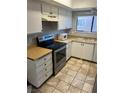 Compact kitchen features stainless steel appliances, light countertops, and tiled flooring at 579 Roxella Ln # D, Las Vegas, NV 89110