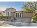 Inviting single-story home with stone accents, mature landscaping, a two-car garage, and a paver driveway at 9765 Skye Star Ave, Las Vegas, NV 89166