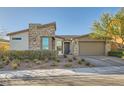Charming single-story home featuring stone accents, desert landscaping, and an attached two-car garage at 9765 Skye Star Ave, Las Vegas, NV 89166