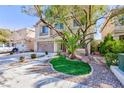 Beautifully landscaped front yard with mature trees and a well-maintained lawn at 10608 Medicine Bow St, Las Vegas, NV 89183