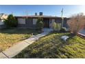 Well-maintained home featuring a lush front yard, mature trees, and an inviting walkway to the entry at 1712 Sweeney Ave, Las Vegas, NV 89104