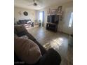 Cozy living room with tile flooring, neutral paint, ceiling fan, and comfortable furniture at 28 Hansen St, Henderson, NV 89015