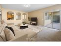Comfortable living room showcasing neutral tones, stylish furnishings, and sliding glass doors at 6360 Bullring Ln, Las Vegas, NV 89130