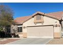 Beige-colored exterior showing the driveway leading up to a two car garage at 7515 Splashing Rock Dr, Las Vegas, NV 89131