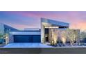 Contemporary home with a three-car garage and modern landscaping, featuring desert plants at 805 Magnum Cliff Ct, Henderson, NV 89012