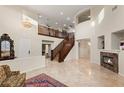 Grand foyer with a staircase, chandelier, marble fireplace, and tiled floors at 1265 Vietti St, Henderson, NV 89012