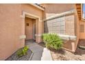 Inviting front entrance with a covered porch, decorative shrubbery, and textured stucco walls at 1562 Pimlico Hills St, Henderson, NV 89014