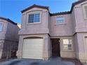 Attractive two-story townhome featuring a garage, covered entrance, and well-kept facade at 1920 Hodgenville St # 106, Las Vegas, NV 89106