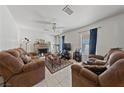 Spacious living room with tile flooring, a ceiling fan, and a cozy fireplace at 214 Earl St, Las Vegas, NV 89101