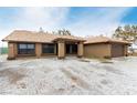 Attractive single-story home featuring a welcoming entrance with columns and desert landscaping at 3051 S Rainbow Ave, Pahrump, NV 89048