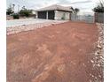Wide shot of front yard with desert landscaping, and a front gate leading to the three-car garage at 308 Cannes St, Henderson, NV 89015