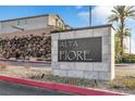 Alta Fiore community sign with rock wall landscaping, a manicured lawn, and palm trees at 40 Verde Rosa Dr, Henderson, NV 89011