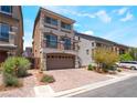 Charming three-story home featuring a balcony, tile roof, and brick driveway at 7029 Parrot Bay Way, Las Vegas, NV 89118