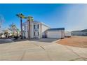Two-story home featuring a grand entrance and a large, open driveway at 7477 Ullom Dr, Las Vegas, NV 89139