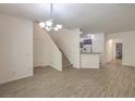 Bright and open-concept living space with modern light fixture and wood-look floors at 9517 Alma Ridge Ave, Las Vegas, NV 89178