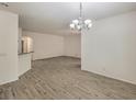 Open-concept living room features wood-look floors and a modern chandelier at 9517 Alma Ridge Ave, Las Vegas, NV 89178