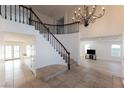 Grand foyer with a striking staircase, tile flooring, and elegant chandelier at 3120 Stern Dr, Las Vegas, NV 89117