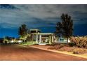 Elegant community entrance featuring modern architecture and landscaping, lit up at night at 10057 Regency Canyon Way, Las Vegas, NV 89148