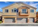 Attractive townhouse exterior with a private balcony, three garages, and neutral stucco at 10074 Aspen Rose St # 101, Las Vegas, NV 89183