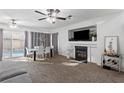 Bright living room with fireplace, ceiling fans and dining area with sliding door to the backyard pool at 10273 Grecian Laurel Ct, Las Vegas, NV 89183