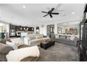 Spacious living room featuring plush seating, ceiling fan, and open concept to kitchen for modern living at 10313 Aragon Crown Rd, Las Vegas, NV 89135