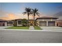 Charming home featuring desert landscaping, a wide driveway, and a three-car garage, beautifully lit at sunset at 1704 Tangiers Dr, Henderson, NV 89012