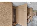 Condo hallway leading to the door of Unit 1007 with a convenient rack for packages at 2200 S Fort Apache Rd # 1007, Las Vegas, NV 89117
