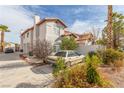 Beige stucco house with a red clay roof and a beige car in the driveway at 3866 Starfield Ln, Las Vegas, NV 89147