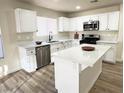 Stylish kitchen featuring white cabinetry, quartz countertops, and stainless appliances at 7329 Cogburn St, Las Vegas, NV 89131