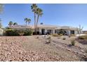 Charming single-story home with desert landscaping, palm trees, and three-car garage at 8290 Gagnier Blvd, Las Vegas, NV 89113