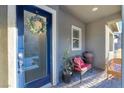 Welcoming front porch with a blue door, wreath, and a cozy sitting area at 905 Belleforte Ln, Las Vegas, NV 89138
