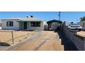 Exterior view of home and covered parking space, with chain-link fence and long driveway at 17 Mallory St, Henderson, NV 89015