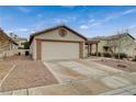 Beige single-story home featuring a two-car garage and desert landscaping at 612 Bullwhip Ct, Henderson, NV 89011