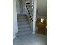 Carpeted staircase with modern railing leading to lower level with tile flooring at 7068 Parrot Bay Way, Las Vegas, NV 89118