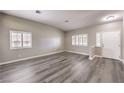 Bright and airy living room with grey wood flooring, white trim, and natural light from the window at 904 Melic Way, North Las Vegas, NV 89032