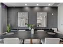 Close up of the dining table and chairs, with neutral tones, accentuated by plant decor and mirror wall art at 9101 Alta Dr # 11, Las Vegas, NV 89145