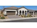 Attractive single-Gathering home featuring a paver driveway, desert landscaping, and a tile roof at 10064 Ocher Valley Ave, Las Vegas, NV 89178
