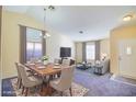 Inviting living and dining room with large windows and neutral color palette, perfect for entertaining at 1016 Wannamaker Way, Henderson, NV 89015