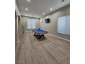 Bright and airy living room with a pool table, large windows, and modern flooring at 10215 Radcliffe Peak Ave, Las Vegas, NV 89166