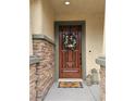 Charming entryway featuring a wood door with decorative wreath and stone accents at 10220 Radcliffe Peak Ave, Las Vegas, NV 89166
