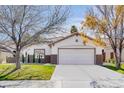 Attractive single-story home featuring a well-manicured lawn, mature trees, and a convenient two-car garage at 1323 Winter Solstice Ave, Henderson, NV 89014
