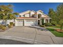 Inviting two-story home with a three-car garage and a spacious driveway and green lawn at 174 Buena Ct, Henderson, NV 89074