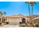 Well-maintained single-story home with desert landscaping, a two-car garage, and tall palm trees at 1805 Joy Grove Ave, Henderson, NV 89012