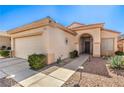 Inviting single-story home with desert landscaping, an arched entryway, and a two-car garage at 1805 Joy Grove Ave, Henderson, NV 89012
