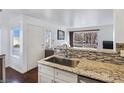 Modern kitchen with stainless steel sink, granite countertops, and mosaic backsplash at 5092 Mandalay Springs Dr # 201, Las Vegas, NV 89120