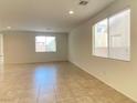 Spacious living room with tile flooring, ample natural light from large windows, and neutral wall colors at 5513 Silent Springs Dr, Las Vegas, NV 89122