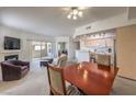 Cozy living room with fireplace, ceiling fan, and adjacent kitchen and dining area at 6909 Cobre Azul Ave # 202, Las Vegas, NV 89108